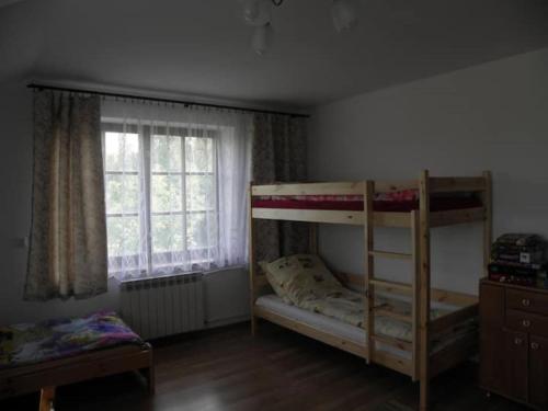 a bedroom with two bunk beds and a window at Siedlisko Pauza in Kozłów