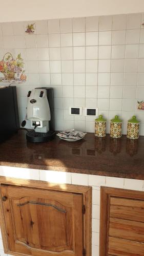 a kitchen counter with a coffee maker on top of it at La piccola grande casetta Titina in Ischia
