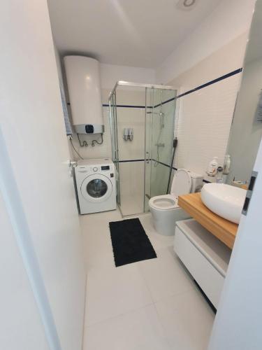 a bathroom with a toilet sink and a washing machine at Sea view Oxygen Neptun in Neptun