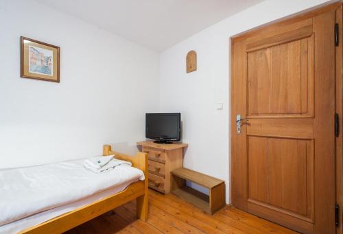 a bedroom with a bed and a tv and a door at Hotel U Malého Vitka in Český Krumlov