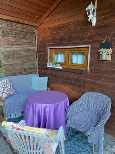 a patio with a purple table and two chairs at Willa nad Sołą guest house in Oświęcim