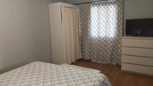 a bedroom with a bed and a dresser and a window at Canto da Manu in Estreito da Calheta