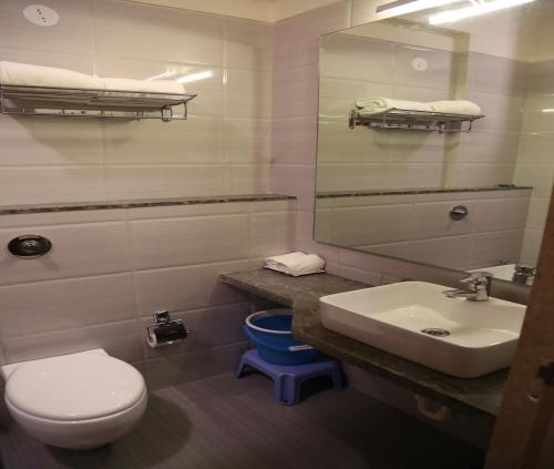 a bathroom with a white toilet and a sink at Sukkur Bhavan's SB Resorts & Lawns in Lonavala
