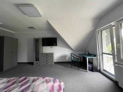 a bedroom with a bed and a desk and a tv at Wegzen in Hévíz