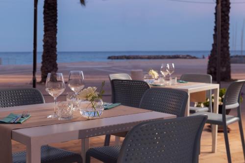 a group of tables with wine glasses on the beach at Hotel Vita Serena in Arma di Taggia