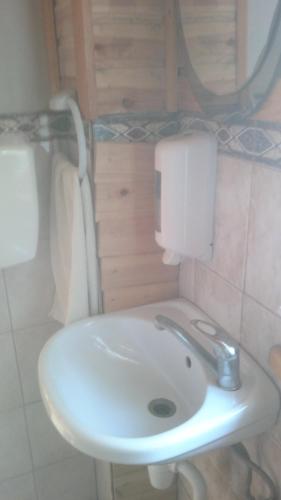 a bathroom with a white sink in a room at Kempings Mežmalas in Usma