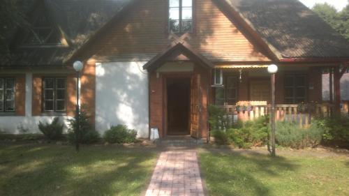 a house with a brick walkway leading to the front door at Kempings Mežmalas in Usma