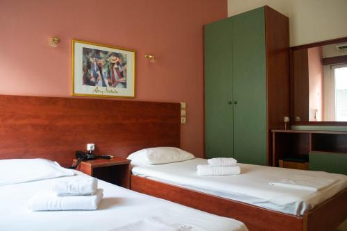 2 camas en una habitación con paredes rojas y armarios verdes en Egnatia Hotel en Ioánina