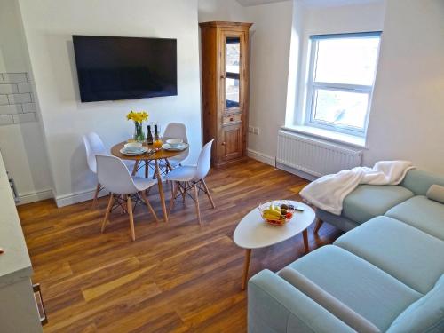 a living room with a couch and a table at Great Orme Apartment by Seaside Llandudno in Llandudno