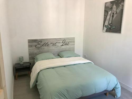 Un dormitorio con una cama con una señal que lee la vida del amor en Appartement 3 pièces lumineux au cœur du village, en Saint-Martin-Vésubie