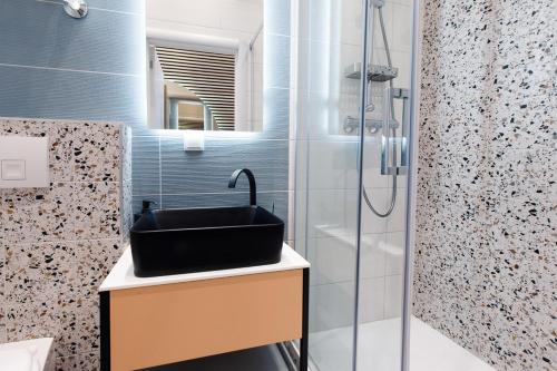ウィーンにあるZeus Design Apartments Unique #36のバスルーム(黒い洗面台、シャワー付)