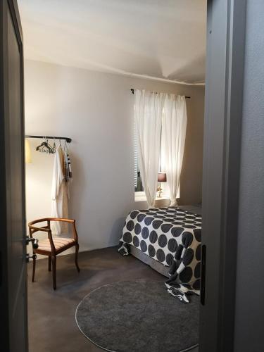 a bedroom with a bed and a chair and a window at Theresa sulla Collina in Passerano 