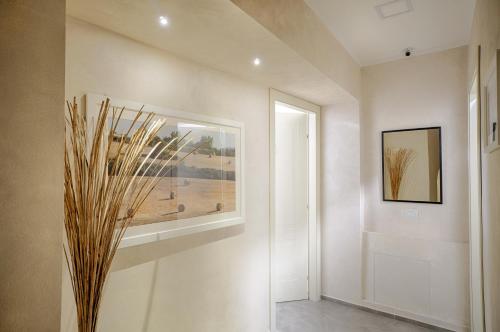 a hallway with a vase on the wall and a window at Via Barocca in Ragusa
