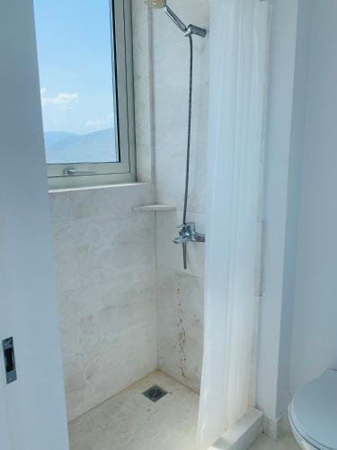 a bathroom with a shower and a toilet and a window at Caldera Blue in Alikí