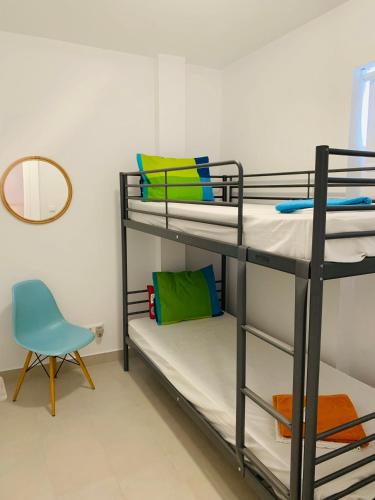 a room with three bunk beds and a blue chair at Caldera Blue in Alikí