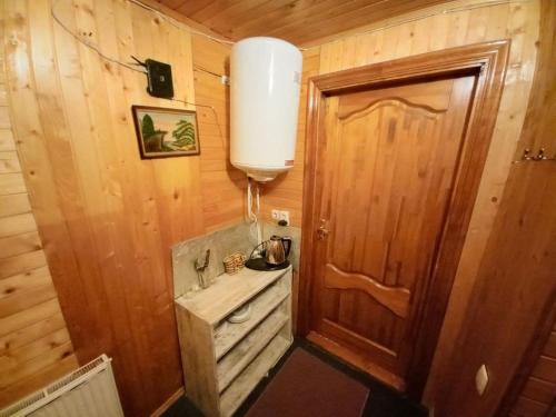 a small bathroom with a wooden door and a sink at У Тараса і Лесі in Yaremche