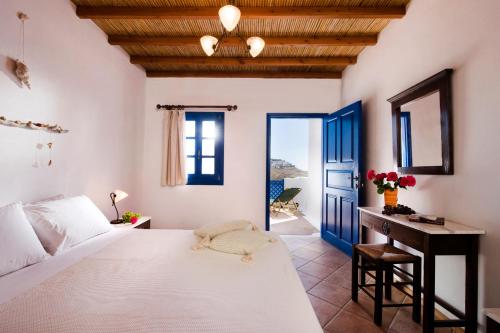 a bedroom with a bed and a desk and a window at Arhitektoniki Studios in Astypalaia