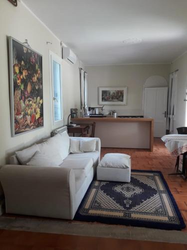 a living room with a white couch and a table at Tenuta Crescentini-ValleMura ,appartamenti con entrata indipendente in San Donà di Piave