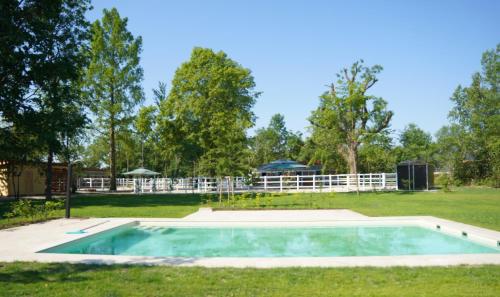 ein leerer Pool in einem Garten mit einem Zaun in der Unterkunft Equiliber Reitkunstzentrum Burgenland in Wulkaprodersdorf