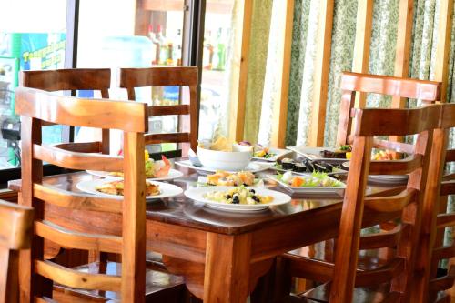 a wooden table with plates of food on it at Eden Resort in Santander