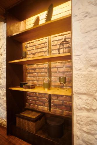 a shelf with a bird cage on a brick wall at Casa da Praça Velha Guest House in Braga