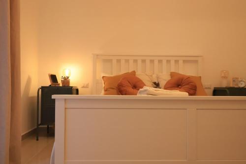 a white bed with orange pillows on top of it at B&B LA TERRAZZA in Terlizzi