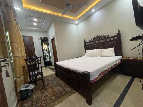 a bedroom with a large bed with white sheets at Star light in Islamabad