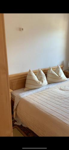 1 dormitorio con 1 cama con sábanas y almohadas blancas en Appartament Anna 4, en Predoi