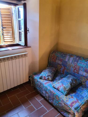 a couch sitting in a room with a window at AGRITURISMO LA PIAGGIA appartamenti a Vivo D'Orcia in Vivo dʼOrcia