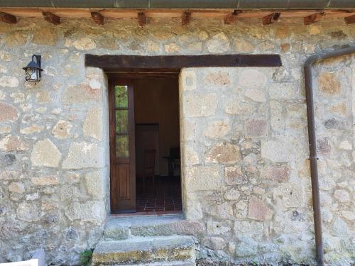 an entrance to a stone building with a wooden door at AGRITURISMO LA PIAGGIA appartamenti a Vivo D'Orcia in Vivo dʼOrcia
