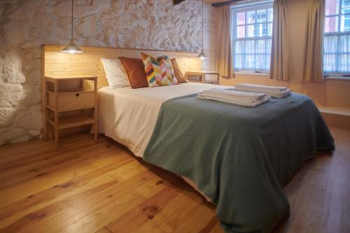 a bedroom with a large bed in a room at Casa da Praça Velha Guest House in Braga