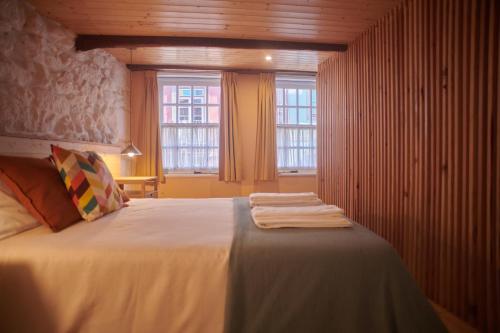 a bedroom with a bed with two towels on it at Casa da Praça Velha Guest House in Braga