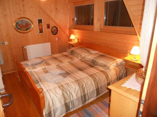 een slaapkamer met een bed in een houten kamer bij Holiday Home Gobela in Kranjska Gora