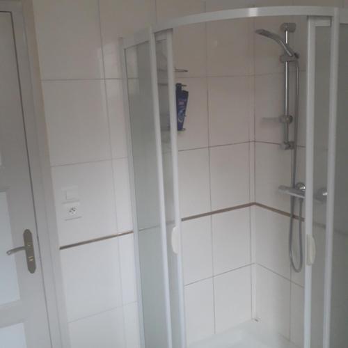 une salle de bain avec une douche avec une porte vitrée dans l'établissement Petite chambre meublée au cœur de ville - chez l'habitant, au Creusot