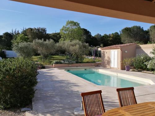 - une piscine dans un jardin avec 2 chaises et une table dans l'établissement Villa gonfaron, à Gonfaron