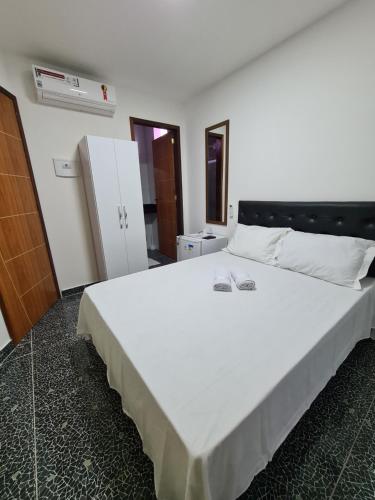 um quarto com uma grande cama branca num quarto em Suites Jangadeiro Maragogi 1 RUA JANGADEIROS 215 em Maragogi