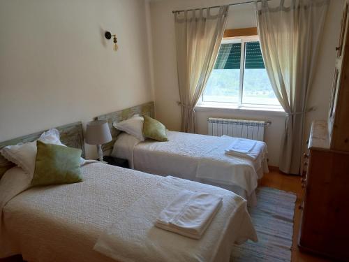a hotel room with two beds and a window at Casa Bela Vista in Bem da Fé