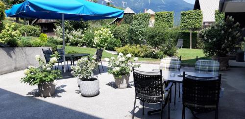 a patio with a table and chairs and a blue umbrella at Apartments Vesna in Bled