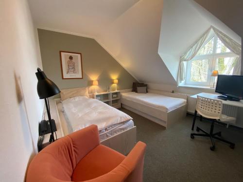 een slaapkamer met 2 bedden en een bureau met een televisie bij Hotel Spitze Warte in Rüthen