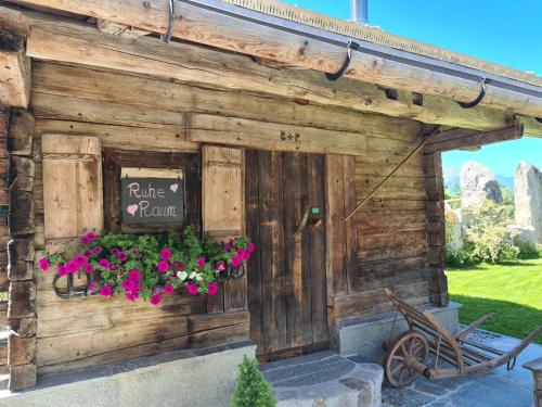 a wooden building with flowers and a sign on it at Hotel Giessenbach in Fügen