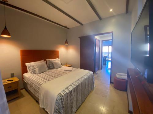 a bedroom with a bed and a table and a door at Taiba Beach Resort 03 Apto 2 quartos in São Gonçalo do Amarante