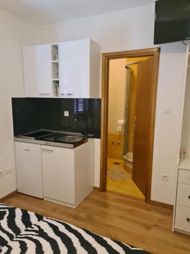 a kitchen with a sink and a stove top oven at Apartments Petrovic in Šilo