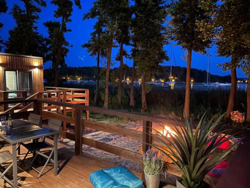 a deck at night with a table and a grill at XOXO Lake House in Giżycko