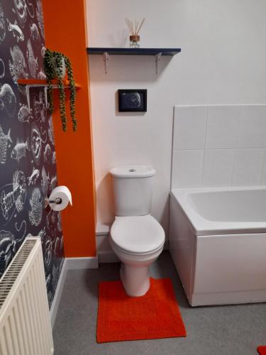 a bathroom with a toilet and a tub and a sink at Ideal Apartment - Sleeps 6 - Parking in Barnsley