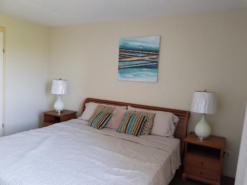a bedroom with a white bed with two lamps at Fabulous Ocean View Apartment in Secure Resort, 5 min Walk to Beaches & Restaurants in Willemstad