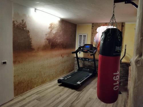 a red surfboard hanging from a room with a treadmill at Garnì Defrancesco in Campitello di Fassa
