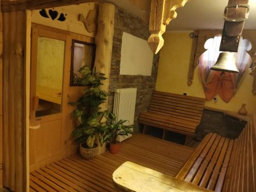 Habitación con 2 bancos de madera y mesa. en Garnì Defrancesco en Campitello di Fassa