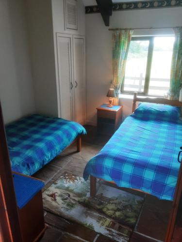 ein Schlafzimmer mit zwei Betten und einem Fenster in der Unterkunft Sharlands Farm Holiday Cottages in Bude