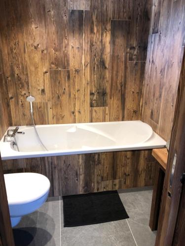une salle de bain avec une baignoire blanche et des toilettes dans l'établissement CHALET HUBERT, à Morzine