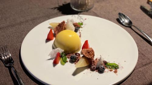 a white plate with food on a table at Hotel Restaurant Urweider in Innertkirchen